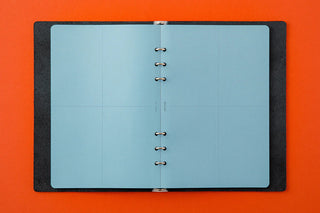 Blue 2mm grid memo pad pages open with metal binder rings, A5