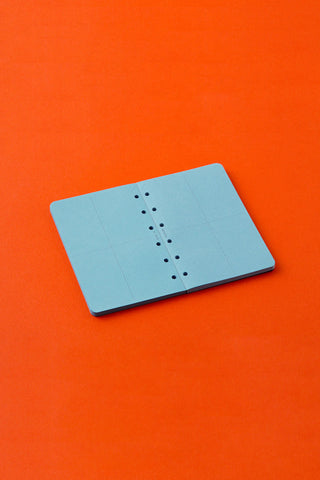 Blue grid memo pad refill with punched holes and binding line