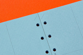 Blue 2mm grid paper close-up with punched binder holes