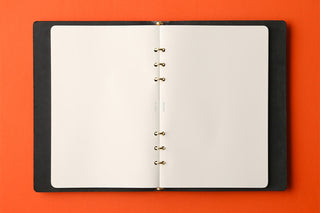 PLOTTER A5 memo pad refill, open spread with gold wire rings and blank pages.