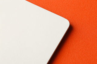 Corner close-up of the white mini memo pad pages on a black cover