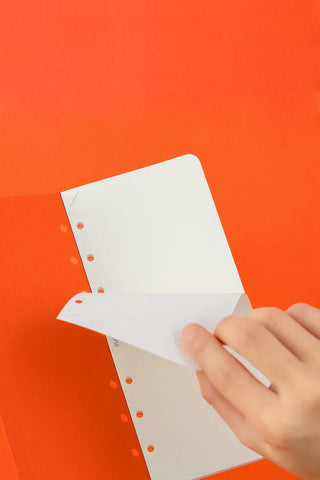 Orange memo pad refill pages being flipped by a hand