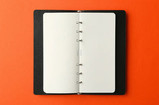 Opened white refill memo pad with metal ring binding on dark cover