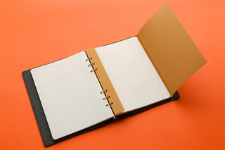 Open A5 planner with black cover, white pages, and tan kraft insert