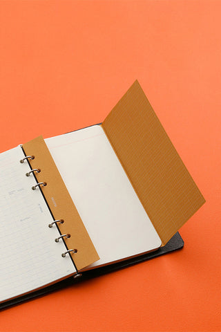 Open binder with white pages, tan cover panel, and metal ring binder posts