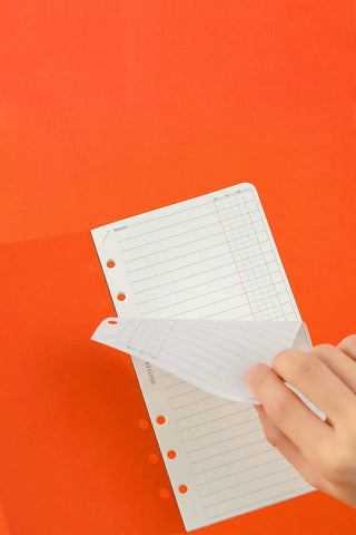 Narrow To Do List refill memo pages with grid lines and punched holes, held by hand