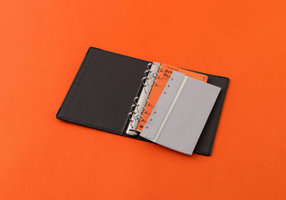 Open narrow binder with silver rings and refill page sections