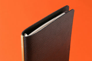 Brown leather-look binder holding Bible-size ruler pad pages with black spine