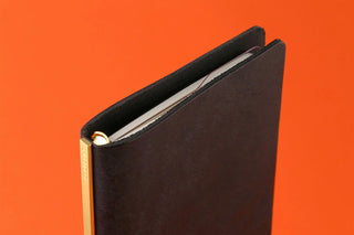 Black ring binder with narrow ruler pad insert and gold metal ring detail