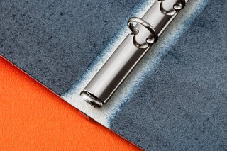 Blue-gray leather binder rings close-up with three metal ring bars