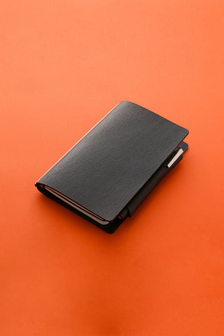 Black leather bible-size penholder, closed with side flap and elastic-style band
