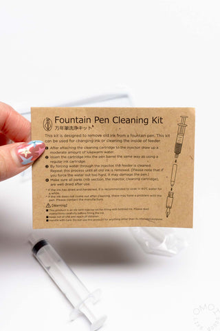 Fountain pen cleaning kit includes instruction card and syringe with clear cartridge