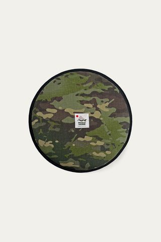 Circular woodland camo Cordura seat pad with black rim and small front label