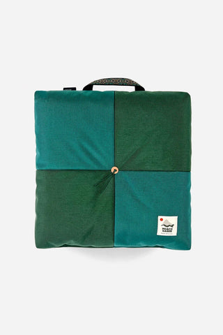 Teal and dark green outdoor cushion with carrying handle and center snap button