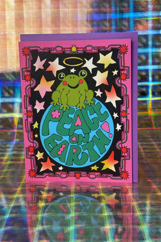 Peace on Earth greeting card with cartoon alien holding peace sign on blue globe