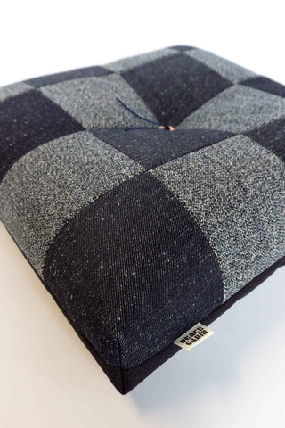 Indigo denim patchwork cushion corner with salt-and-pepper checker pattern and label