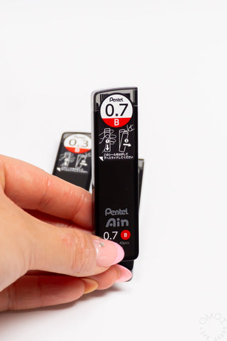 B pencil lead refill for 0.7 mm, held by fingers