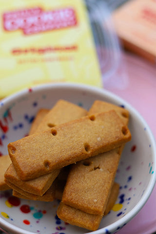 Butter shortbread cookies stacked in a bowl with small colored sprinkles