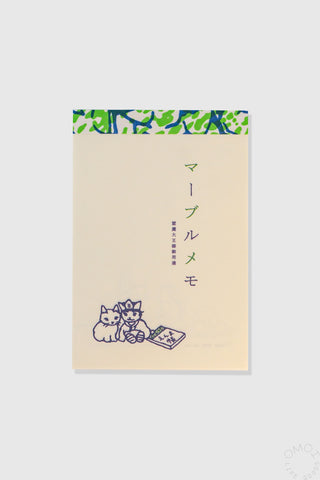 Beige cat memo pad with green patterned top strip and two cats holding a note