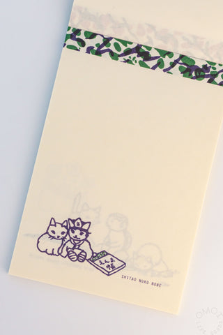 Beige cat memo pad with green patterned top strip and two cats sitting by a note