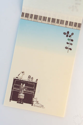 Cat and piano letter pad with piano-key strip across the top and cat musician scene