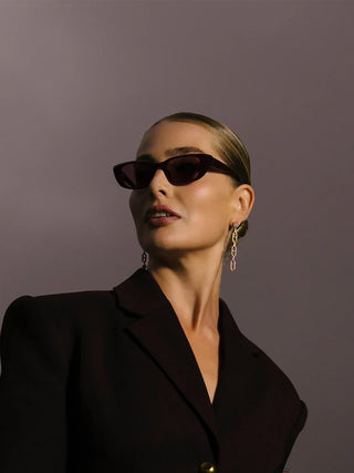 Iwa sunglasses on model: dark cherry frames with rose tinted lenses