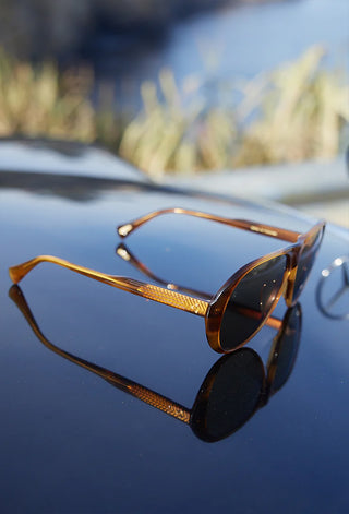 Amber tortoise sunglasses with mirrored lenses and slim metal frame detail