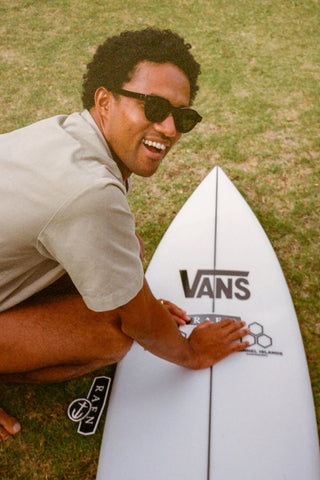 Round sunglasses on smiling person outdoors, light frame and dark lenses