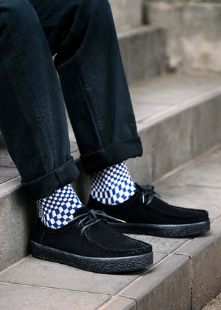 Checkerboard patterned socks in blue and white with ribbed cuff