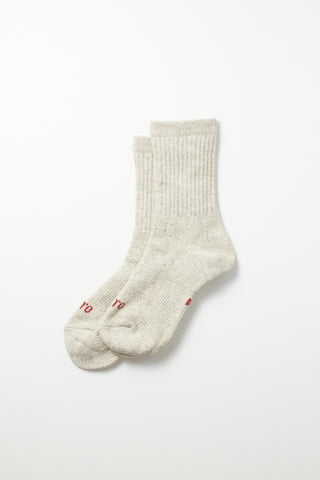 Light gray mini crew sock; ribbed knit with small red logo embroidery at the toe.