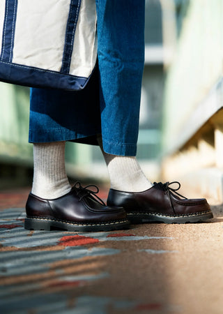 Light gray mini crew socks on feet; ribbed knit, cuffed crew height.