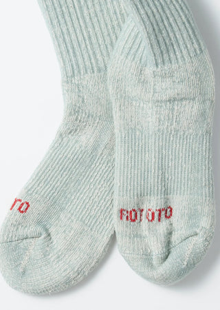 Close-up of light blue mini crew socks showing red logo embroidery on the toe.