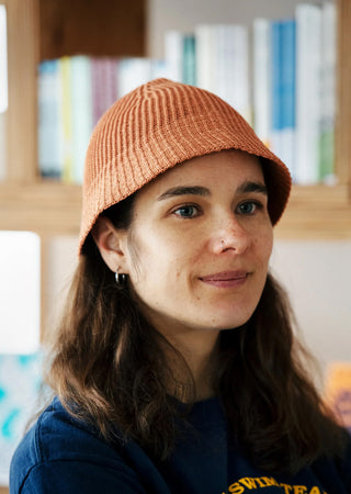 Apricot flax-touch knit beanie hat with ribbed texture, model portrait