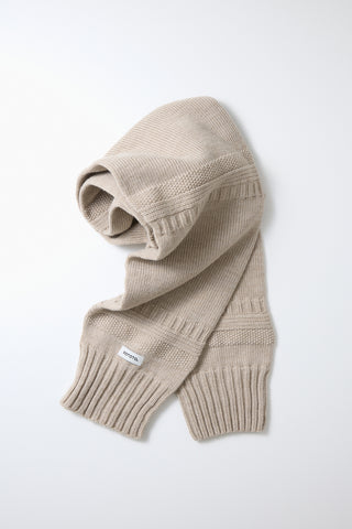 Light beige knit sweater sleeve muffler with ribbed cuffs and small logo patch.