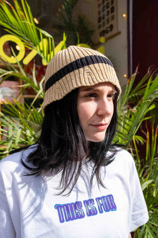 Beige knit beanie with wide black stripe, ribbed cuff