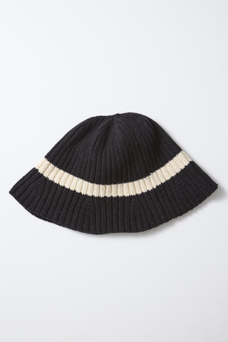 Black ribbed knit hat with wide cream stripe across the brim