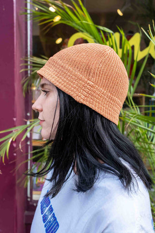 Apricot flax-touch knit beanie hat with ribbed texture, side profile view