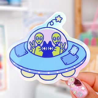 Radhia Rahman UFO Kuni sticker, blue cartoon spaceship with two alien faces