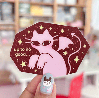 Maroon cat sticker with stars and text "up to no good" on a hexagon shape