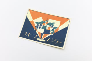 Retro fruit parlor sticker card with orange top, blue border, and grapes checker emblem