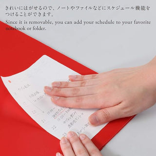 Hands applying a beige removable weekly calendar sticker sheet