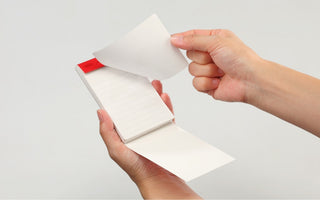 STÁLOGY 026 memo pad with lined white sheets, held open by two hands