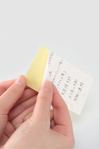 STÁLOGY removable to-do stickers, yellow and white memo strips being peeled by hand