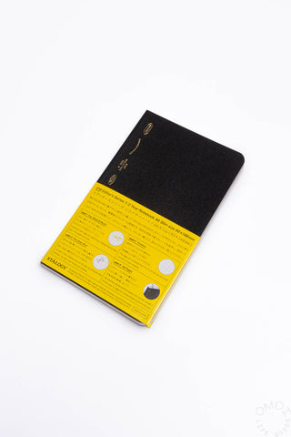 Black slim notebook with yellow label band and vertical spine