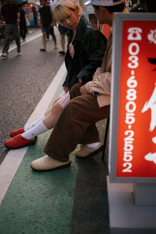 Beige slip-on slippers worn on the street with white socks