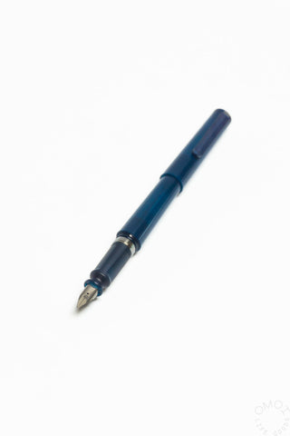 Translucent dark blue fountain pen with metal nib and clip, closed