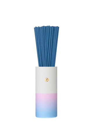 Blue incense sticks in a white-to-blue gradient cylinder holder with small gold seal
