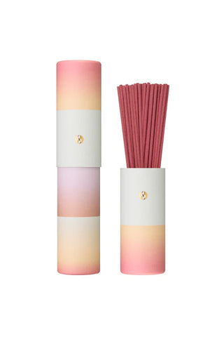Gradient incense cylinder with strawberry-pink incense sticks and gold logo