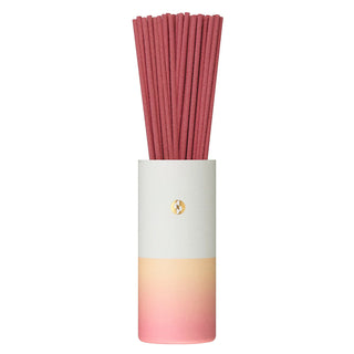 Strawberry-pink incense sticks in a gradient cylinder sleeve with gold logo
