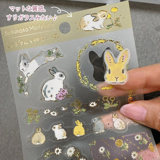 Gold-foil frosted clear stickers with bunny and flower cutouts, held in hand